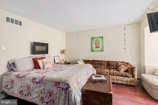 bedroom with visible vents and wood finished floors