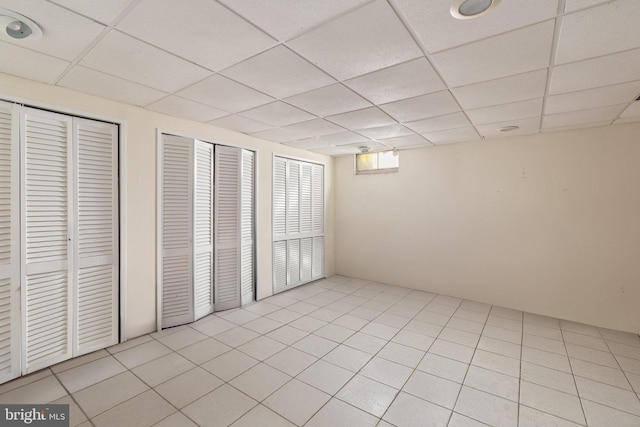 interior space featuring light tile patterned flooring and a paneled ceiling