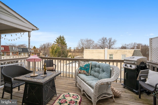 wooden terrace with grilling area and an outdoor living space