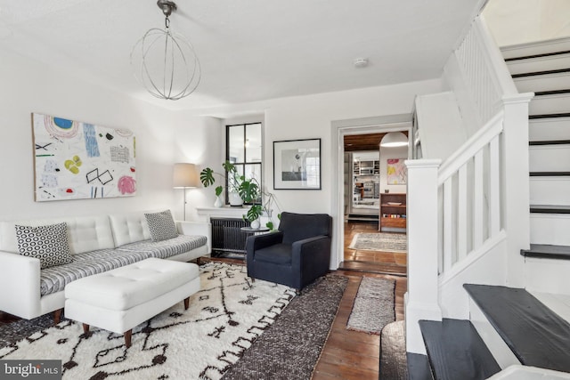 living area with stairs, radiator heating unit, and wood finished floors