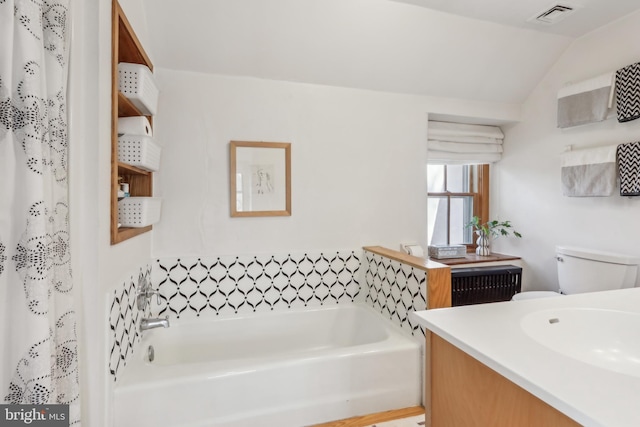 full bath featuring visible vents, toilet, vaulted ceiling, vanity, and a bath