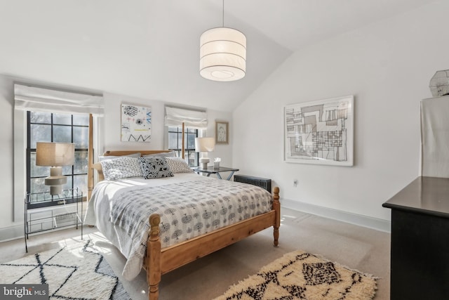 carpeted bedroom featuring lofted ceiling and baseboards