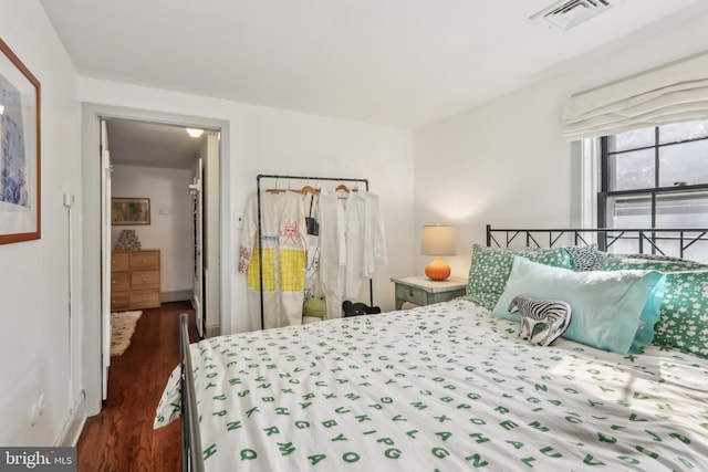 bedroom featuring visible vents and dark wood-style flooring