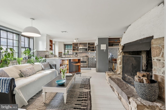 living room featuring plenty of natural light, a fireplace, and visible vents