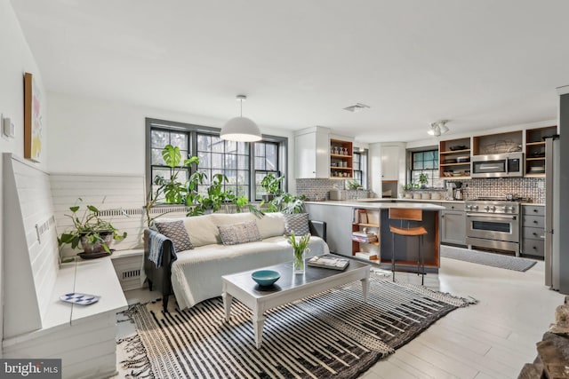 living area featuring light wood-style flooring and visible vents