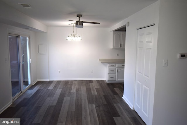 unfurnished dining area with baseboards, ceiling fan, visible vents, and dark wood-style flooring