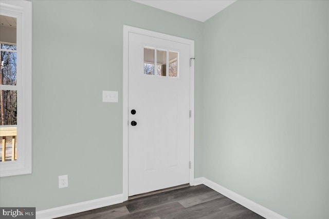 foyer entrance with dark wood-type flooring and baseboards