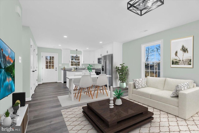 living room featuring baseboards, dark wood finished floors, a wealth of natural light, and recessed lighting