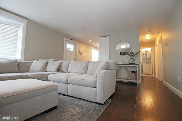 living room with baseboards, dark wood-type flooring, and recessed lighting