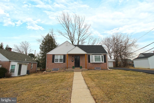 view of front of property with a garage, brick siding, and a front lawn