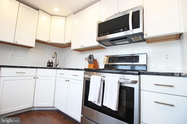 kitchen with appliances with stainless steel finishes, white cabinetry, and backsplash