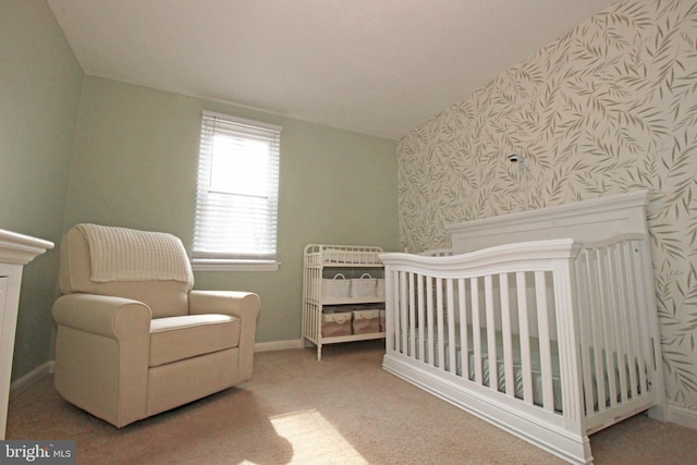 bedroom featuring carpet floors, lofted ceiling, a nursery area, baseboards, and wallpapered walls