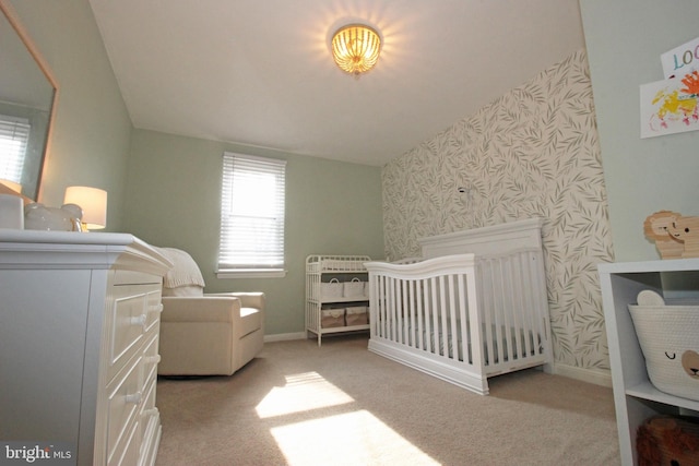 carpeted bedroom with a nursery area, baseboards, and wallpapered walls