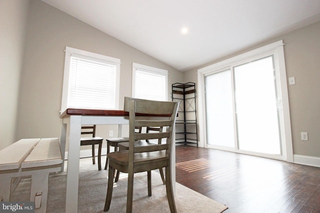 dining space featuring vaulted ceiling, wood finished floors, and baseboards