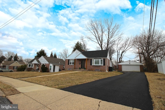 ranch-style house featuring an outbuilding, brick siding, a detached garage, and a front lawn