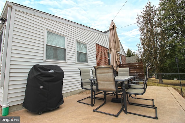 view of patio / terrace featuring outdoor dining space, a grill, and fence