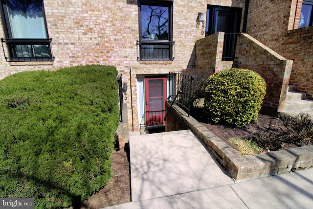 view of exterior entry featuring brick siding