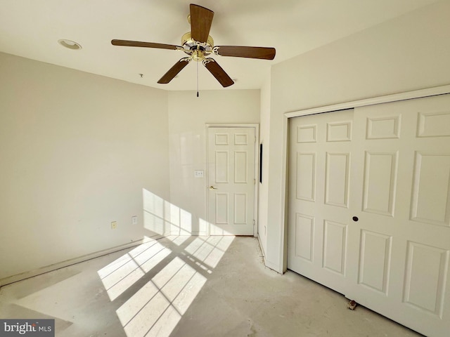 unfurnished bedroom featuring concrete flooring, a closet, and ceiling fan