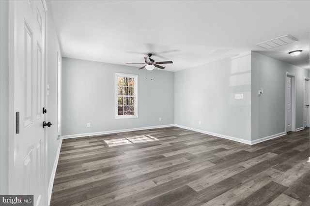 empty room featuring ceiling fan, wood finished floors, visible vents, and baseboards