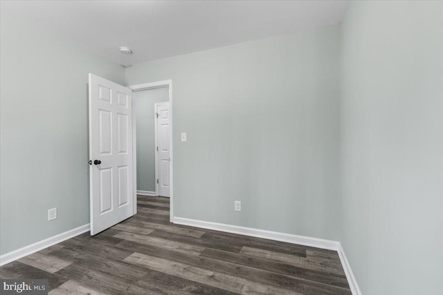 unfurnished room with dark wood-style floors and baseboards