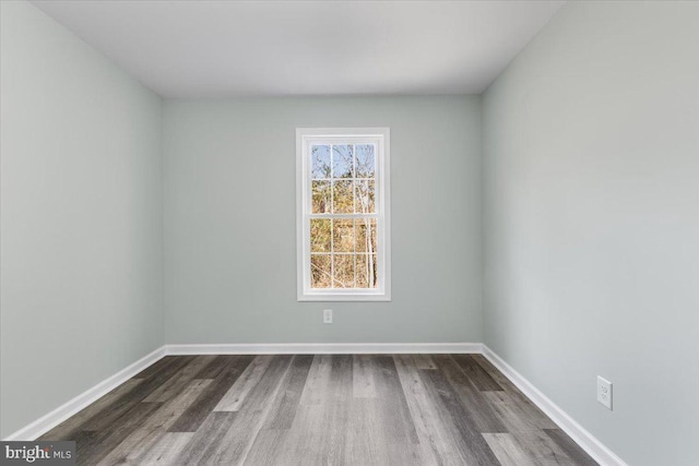 spare room with dark wood-style floors and baseboards