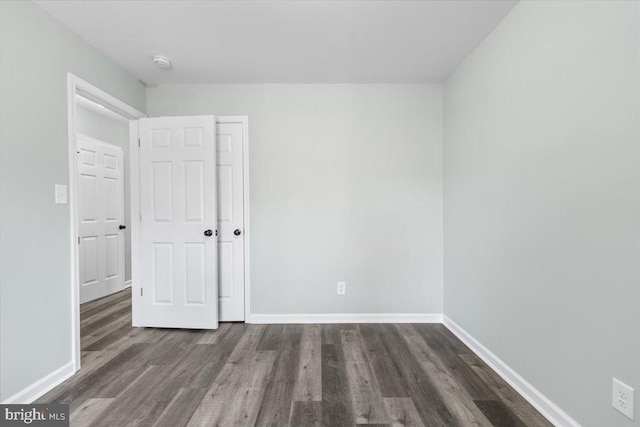 unfurnished bedroom featuring wood finished floors and baseboards