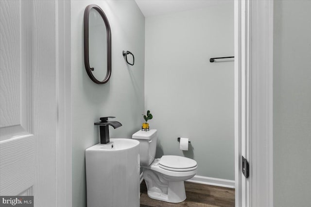 bathroom featuring baseboards, toilet, and wood finished floors