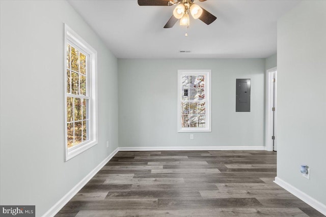 spare room featuring a wealth of natural light, electric panel, and baseboards