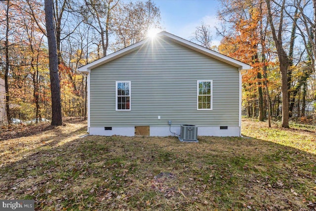 view of property exterior featuring crawl space, central AC unit, and a yard