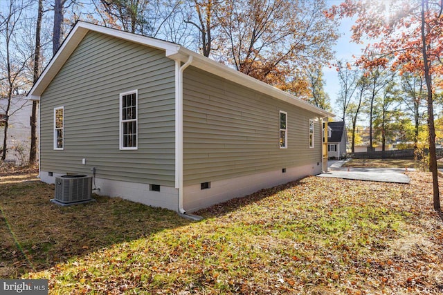 view of side of home with central AC, crawl space, a patio area, and a lawn