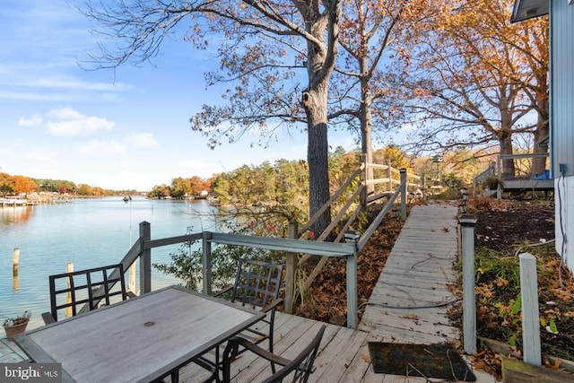 dock area with outdoor dining space and a water view