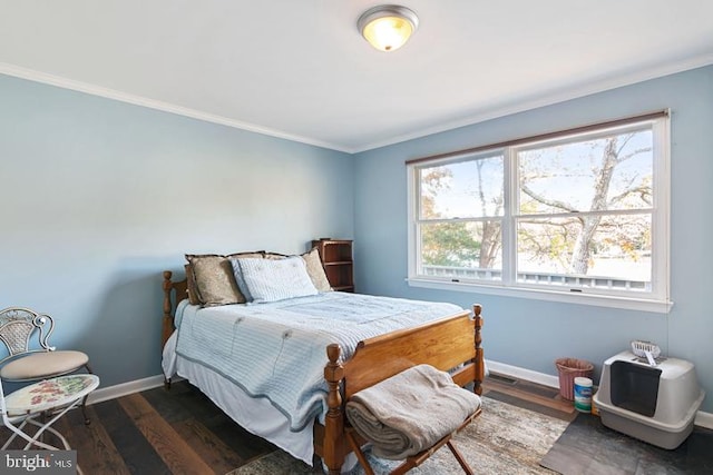 bedroom with ornamental molding, dark wood finished floors, and baseboards