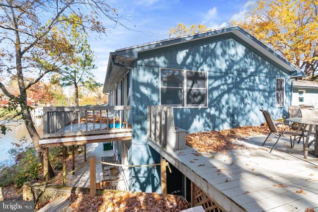 rear view of house with a deck and outdoor dining space