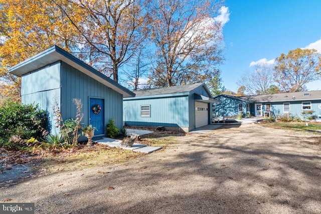 mid-century inspired home with a garage and an outbuilding