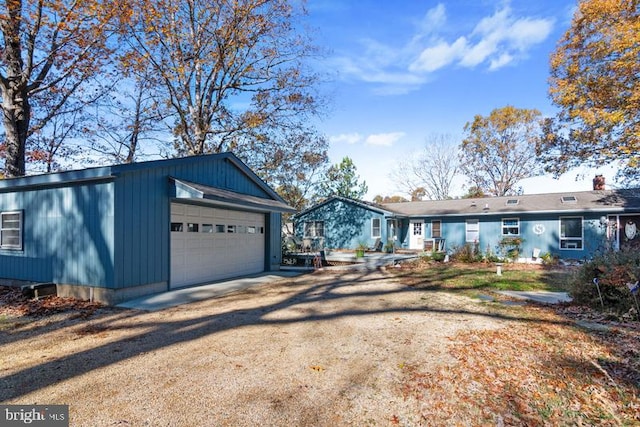 view of front of house with a garage, driveway, and an outdoor structure