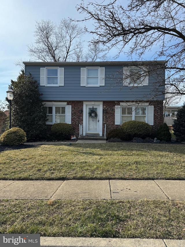 colonial house with brick siding and a front yard