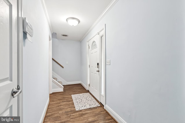 interior space featuring baseboards, wood finished floors, ornamental molding, and stairs