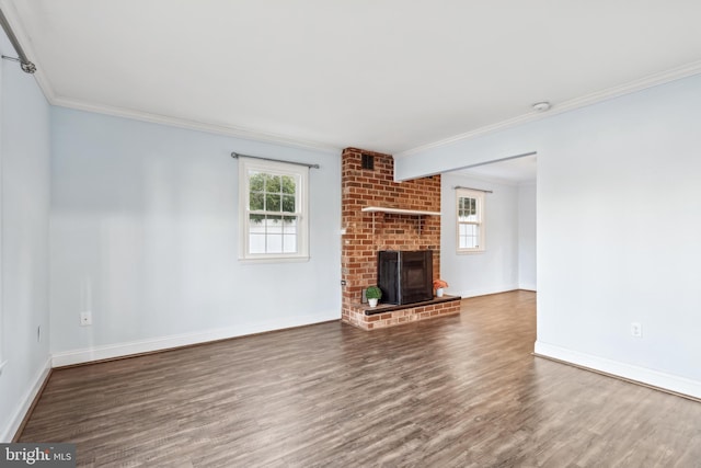 unfurnished living room featuring a fireplace, crown molding, wood finished floors, and baseboards