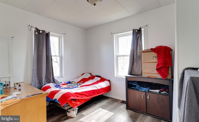 bedroom with multiple windows and wood finished floors