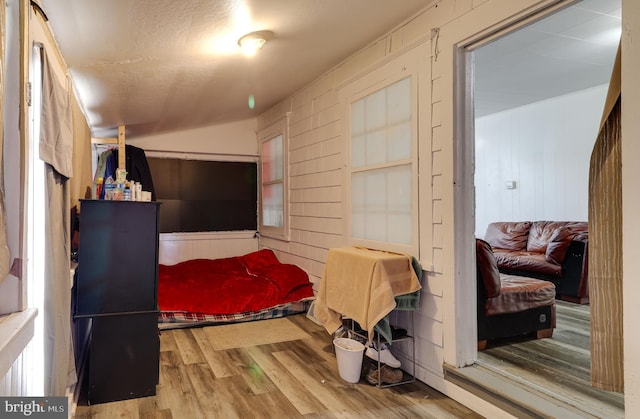 bedroom with vaulted ceiling and wood finished floors