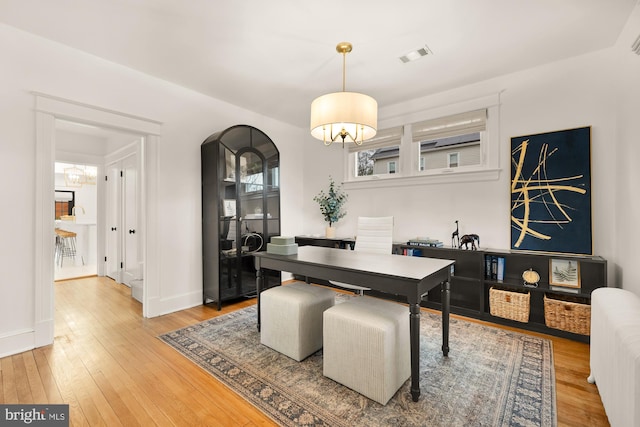 dining area featuring light wood-style flooring, visible vents, radiator heating unit, and baseboards