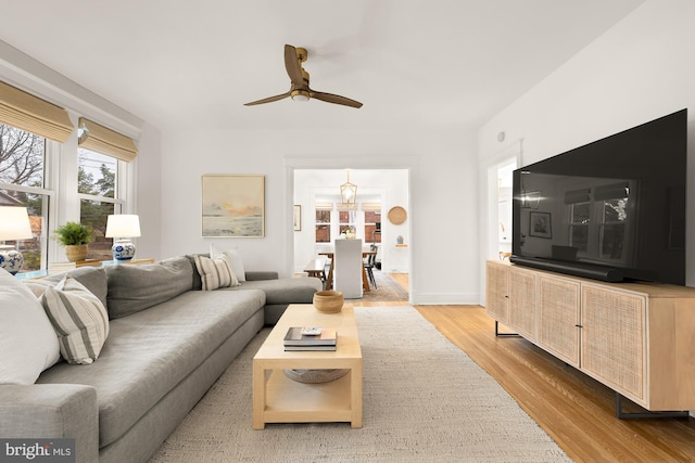 living area with a ceiling fan and wood finished floors