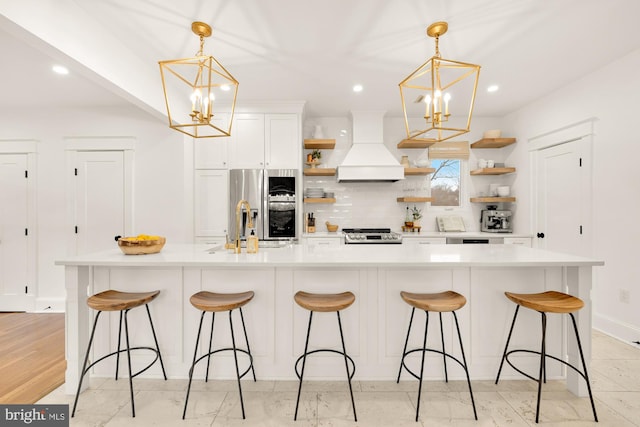 kitchen with decorative backsplash, appliances with stainless steel finishes, an inviting chandelier, custom exhaust hood, and open shelves