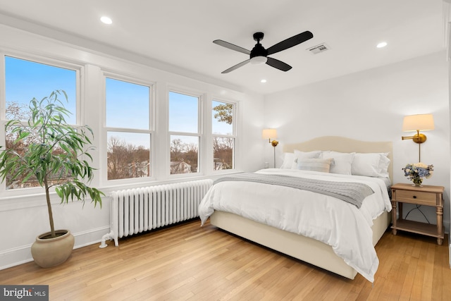 bedroom with recessed lighting, radiator, visible vents, and wood-type flooring