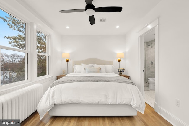 bedroom featuring recessed lighting, visible vents, baseboards, light wood-type flooring, and radiator heating unit