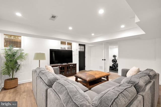 living room with baseboards, light wood finished floors, visible vents, and recessed lighting