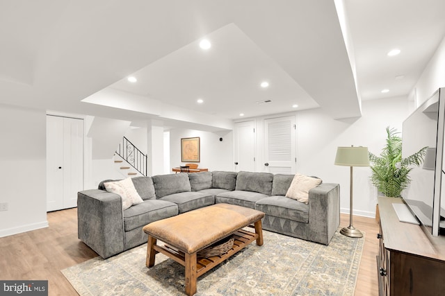 living room with light wood-style floors, stairs, and recessed lighting