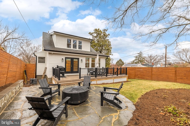 back of house with french doors, a patio, an outdoor fire pit, a fenced backyard, and a wooden deck