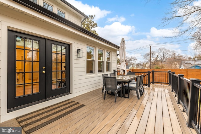 wooden deck featuring outdoor dining space, french doors, and fence