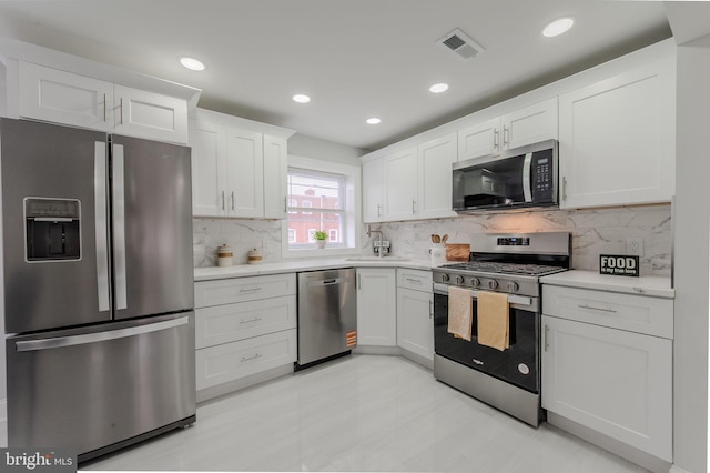 kitchen with stainless steel appliances, light countertops, visible vents, and white cabinetry